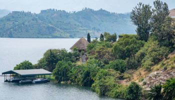 Rwanda Honeymoon Safari A picturesque sunset cast over a tranquil Lake Kivu, with various buildings clearly visible in the background creating an enchanting scene, Rwanda